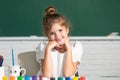 Funny school girl face. Child girl drawing with coloring pens paintind. Portrait of adorable little girl smiling happily