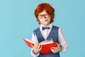 Funny schoolboy with book making face Royalty Free Stock Photo