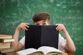 Funny schoolboy hiding behind book Royalty Free Stock Photo