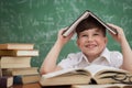 Funny schoolboy holding book over head Royalty Free Stock Photo