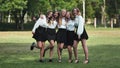 Funny schoolgirls posing and goofing around in a meadow.