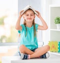 Funny schoolkid holding opened book