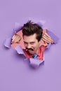 Funny seducer man peeking out of torn paper Royalty Free Stock Photo