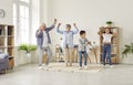 Funny senior couple at home having fun and dancing with their two grandchildren. Royalty Free Stock Photo