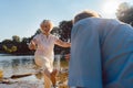 Funny senior couple playing with water at the river in a sunny day of summer Royalty Free Stock Photo