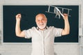 Funny senior teacher in the classroom on blackboard background. Old fun professor in high school or university. Teachers Royalty Free Stock Photo