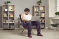 Funny serious fat man in pajamas and eyewear working online on laptop from home Royalty Free Stock Photo