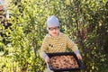 Funny seven year old Caucasian boy holding a large fruit cake in the summer