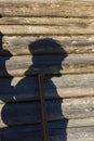 Funny shadow of a person on old log wall like witch silhouette