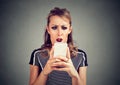 Funny shocked scared woman looking at phone seeing bad news photos message with disgusting emotion on face Royalty Free Stock Photo