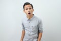 Funny shocked and surprised face of asian Indonesian man, open wide mouth say wow, on isolated backgorund Royalty Free Stock Photo