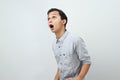 Funny shocked and surprised face of asian Indonesian man, open wide mouth say wow, on isolated backgorund Royalty Free Stock Photo