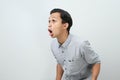 Funny shocked and surprised face of asian Indonesian man, open wide mouth say wow, on isolated backgorund Royalty Free Stock Photo