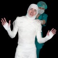 Funny sick in bandage and nurse on black