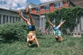 Funny sisters girls doing cartwheel on a backyard. Excited joyful kids playing outdoor. Happy lifestyle childhood and freedom Royalty Free Stock Photo