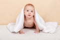 Six month old baby lying on a bed and having fun under towel at home Royalty Free Stock Photo