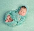 Funny sleeping newborn on blue blanket and in diaper