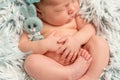 Funny sleepy newborn holding little grey toy, closeup