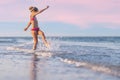 Girl playing with waves kicking and spinning under the summer sun enjoying the vacation Royalty Free Stock Photo