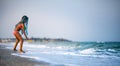 Girl playing with waves kicking and spinning under the summer sun enjoying the vacation Royalty Free Stock Photo