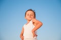 Funny small boy with grimace in white shirt on blue sky copyspace background Royalty Free Stock Photo