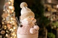 Funny small cute snowman toy figure in pink hat and scarf. Royalty Free Stock Photo