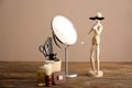 Funny small mannequin with mustache and foam in front of mirror on wooden table Royalty Free Stock Photo