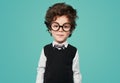 Funny smart kid in round eyeglasses smiling in studio