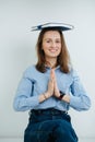 Funny smiling business woman meditating with a journal on top of her head