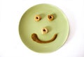 Funny smiling face on green plate from round crackers and mustard Royalty Free Stock Photo