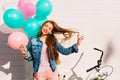 Funny smiling girl posing, playing with long hair and listening music after morning bicycle ride. Pretty female