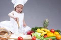 Funny Smiling Little Caucasian Girl In Cook Uniform Making a Mix of Flour, Eggs and Vegetables Royalty Free Stock Photo
