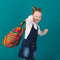 Funny smiling little girl with big backpack jumping and having f Royalty Free Stock Photo