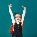Funny smiling little girl with big backpack jumping and having f Royalty Free Stock Photo