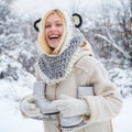 Funny smiling Model Girl laughing and having fun in winter park. Beautiful happy laughing young woman wearing winter hat Royalty Free Stock Photo