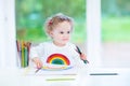 Funny smiling toddler girl drawing a rainbow Royalty Free Stock Photo