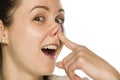 A funny smiling woman touching her nose on white Royalty Free Stock Photo