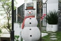 Funny snowman near house. Festive outdoor Christmas decoration