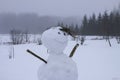 Funny snowman on snow covered rural field
