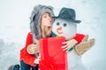 Funny snowmen. Happy smiling girl kissing snowman on sunny winter day. People love winter. Snowman. Beauty Winter Girl