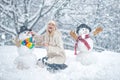 Funny snowmen. Happy smiling girl make snowman on sunny winter day. People in snow. Snowman. Beauty Winter Girl with Royalty Free Stock Photo