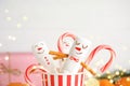 Funny snowmen made of marshmallows in paper cup, closeup. Bokeh effect