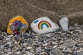 Funny stones that are painted are on the beach, there are several painted motifs