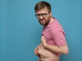 Funny, strange man shows and holds hands his excess fat on his stomach. Copy space. Overweight person. Healthy lifestyle Royalty Free Stock Photo