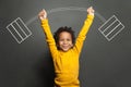 Funny strong black kid with barbell in her hands on chalkboard background