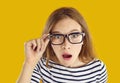 Funny student girl in glasses looking at camera with shocked, astonished face expression Royalty Free Stock Photo