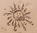 Funny sun and smile drawing on beach sand Royalty Free Stock Photo