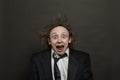 Funny surprised excited businessman with hair up and opened mouth posing on black background, studio portrait Royalty Free Stock Photo