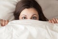 Funny surprised girl covering face with white blanket, headshot Royalty Free Stock Photo