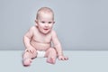 Funny sweet toddler boy sitting on white floor in diaper and looking to the side isolated Royalty Free Stock Photo